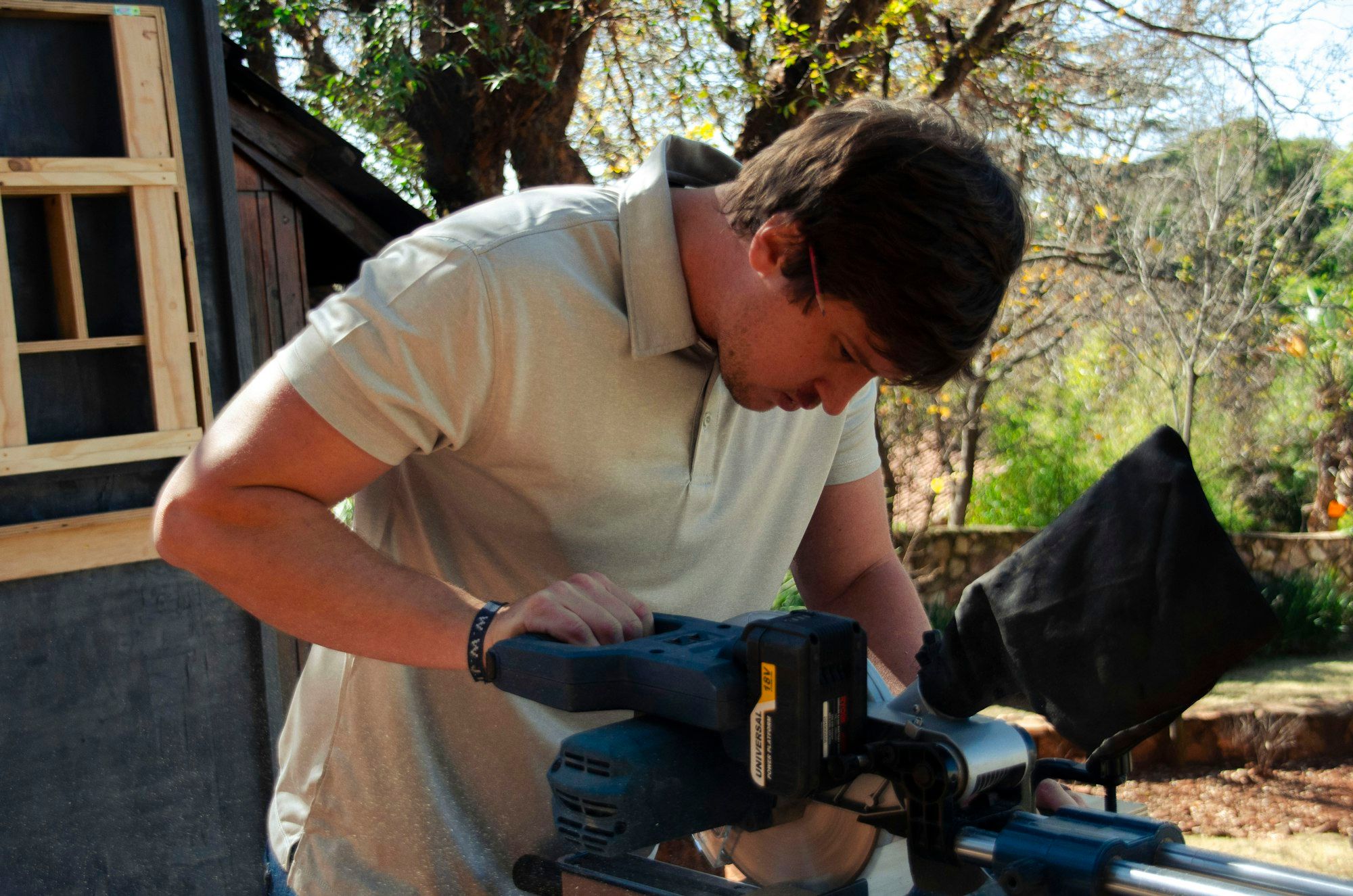 Carpenter cutting timber with a circular saw in a workshop